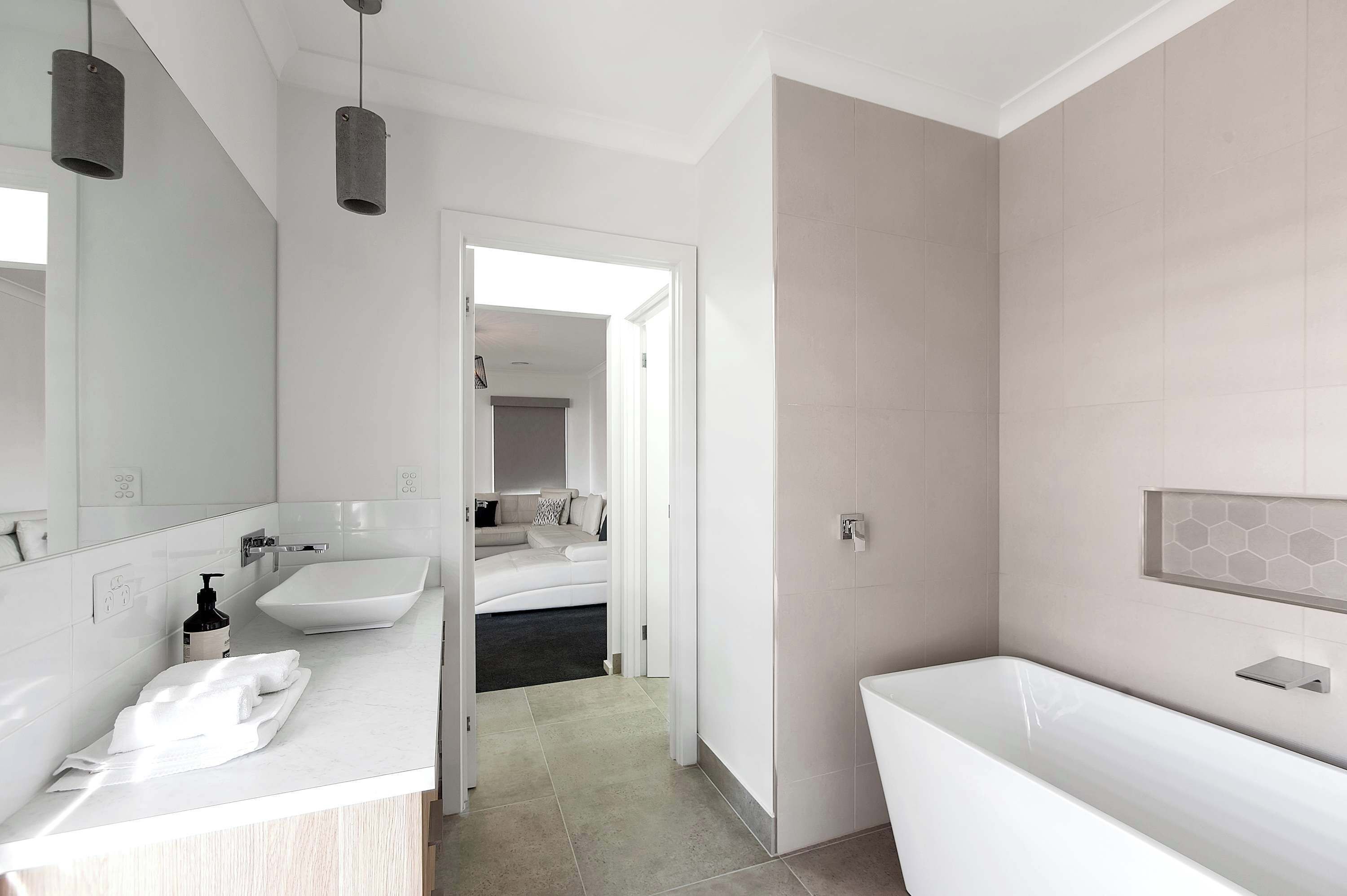 A modern bathroom with a white sink, a bathtub, and a shower area.