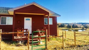 A wooden cabin with a front porch, a small window, and a door marked "WELCOME".