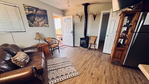 A spacious living room with a leather couch, patterned rugs, and a fireplace.