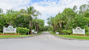 Une route menant au Key West Golf Club, bordée de chaque côté d’une végétation luxuriante et de palmiers.