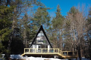 A cabin with a triangular roof, surrounded by trees and snow. - Mod A Frame Cabin in the Woods with Hot Tub -close to Mt. Snow & Stratton! (Wardsboro)