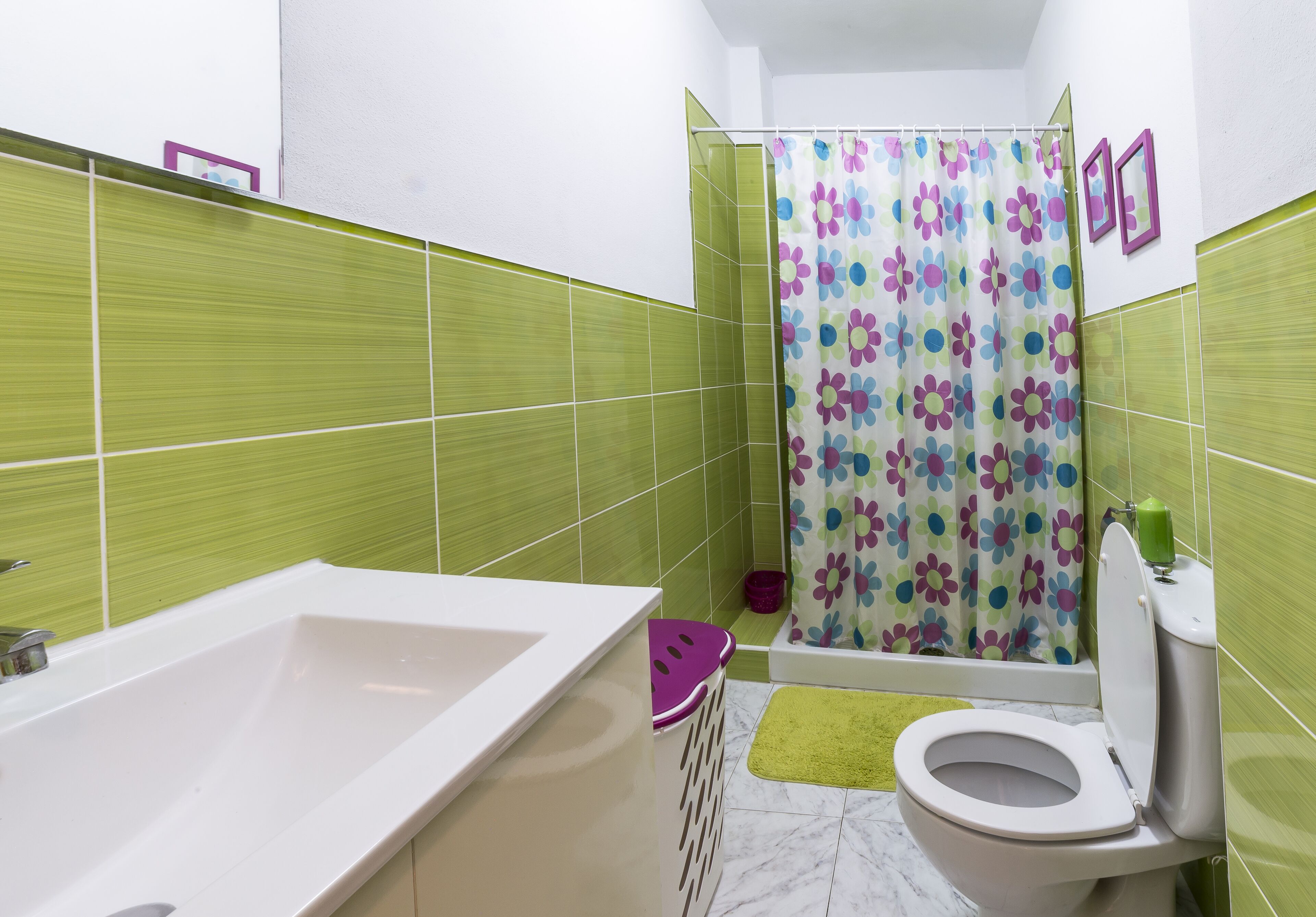 Un baño con bañera, inodoro y cortina de ducha.