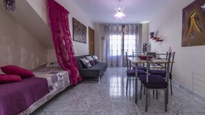 A living room with a sofa, a dining table with chairs, and a ceiling fan. - Vacational Housing CAÑAMO, Feel the Quiet Difference .... (Tamaduste)