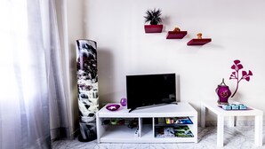 A modern living room with a TV, shelves with decorative items, and a large vase. - Vacational Housing CAÑAMO, Feel the Quiet Difference .... (Tamaduste)