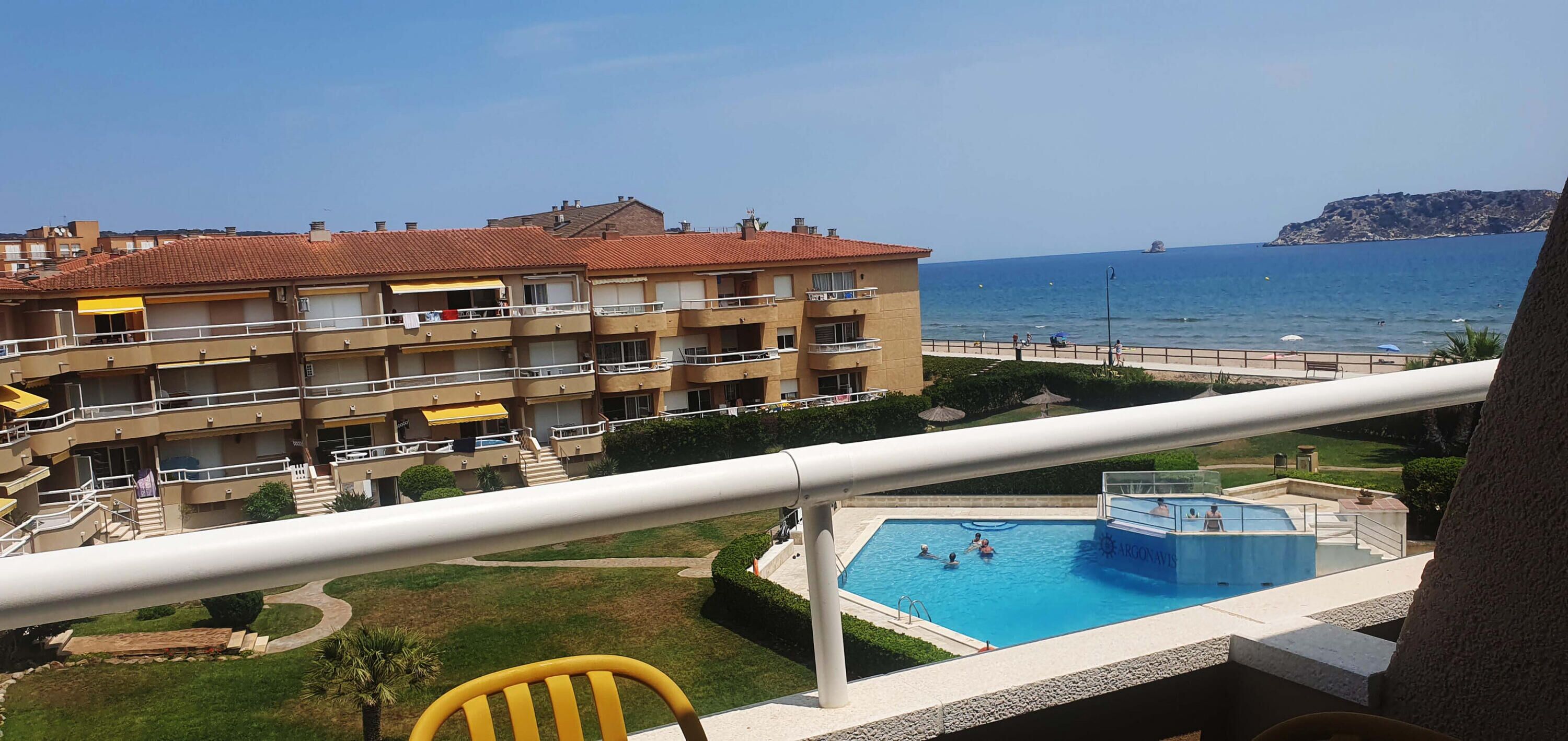 A hotel with a pool, balconies, and a view of the sea.