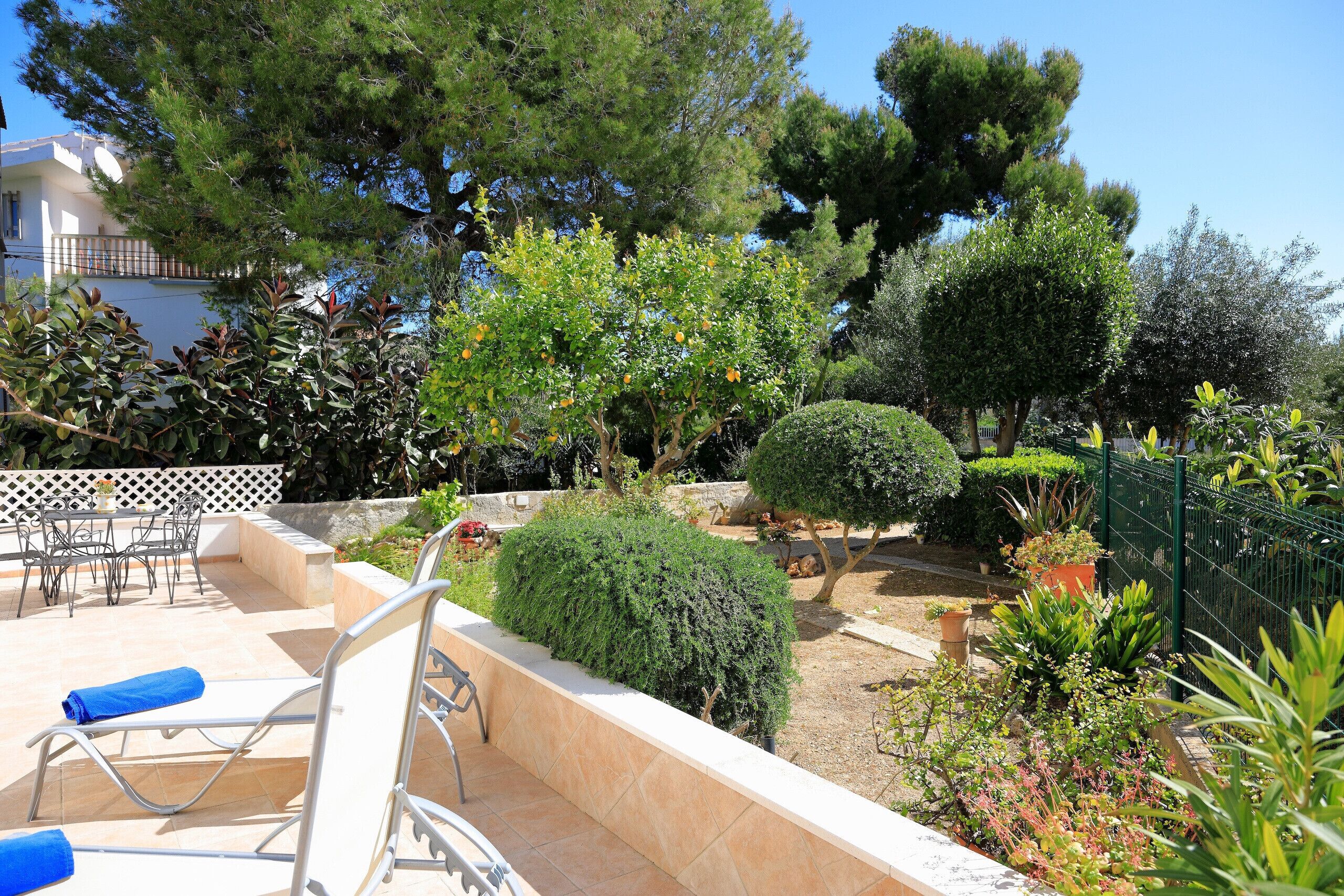 Un’area patio con mobili da esterno, una piccola piscina e diverse piante.