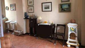 A dining area with a table, chairs, and a decorative cabinet. - Apartment in Taormina center (Taormina)