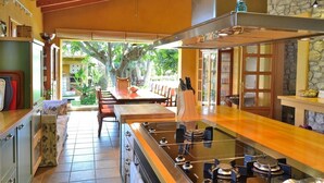 Una cocina amplia con mesa de fútbol, armarios de madera y una pared de acento de piedra.