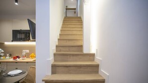 Una scala conduce a un pianerottolo, dove si intravede una zona cucina a sinistra.