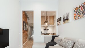 Una sala de estar moderna con un televisor de pantalla plana, un sofá y una mesa de centro.