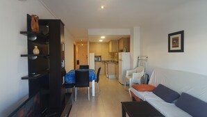 Un espace de vie compact comprenant un coin repas, une kitchenette et un canapé.