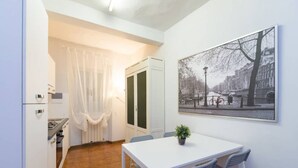 A compact kitchen with a dining area, a white table, and chairs. - Uffizi apartment Spacious and comfortable apartment (Firenze)