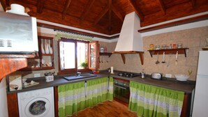 A kitchen with wooden cabinets, a washing machine, and a large window.