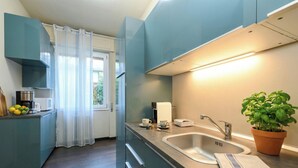 A modern kitchen with a sink, a coffee machine, and a potted basil plant. - Desenzanoloft A Casa di Sara  (Desenzano del Garda)