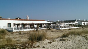 A coastal building with a white facade, a red-tiled roof, and a bell tower. - Casa Magaída, AC, with terrace, near the Ria (Luz (Luz de Tavira))