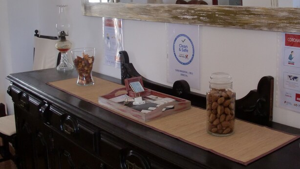 Una habitación con una mesa de madera, un espejo, un reloj y un cartel en la pared.