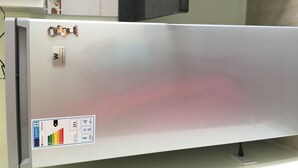 A stainless steel refrigerator with a water dispenser, energy efficiency label, and a nameplate. - Higuey Center City, George City (Higuey)