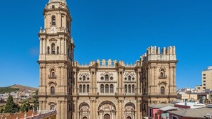 A large, historic building with a prominent bell tower and multiple arches.