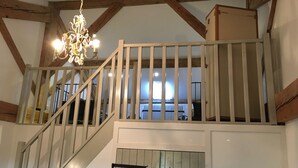 Un escalier avec des poutres en bois et un lustre.