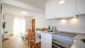 A modern kitchen with white cabinets, a granite countertop, and a built-in oven. - Apartment in beachfront Albaranas (Denia)