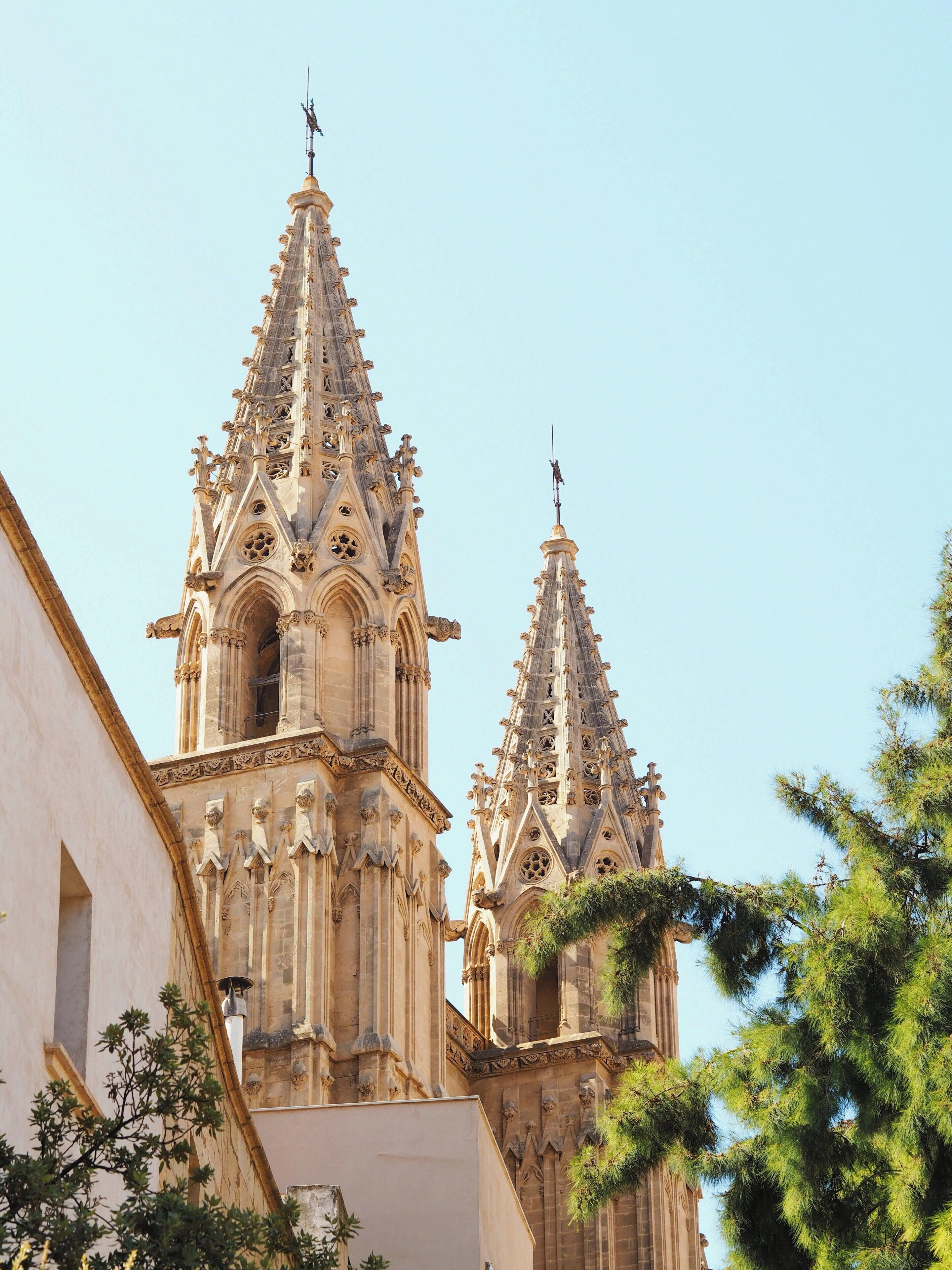 A historic cathedral with intricate Gothic architecture, featuring two tall spires and detailed stone carvings.