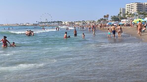 A crowded beach with people swimming and walking along the shore. - Apartment in Torremolinos (La Carihuela area) Erisa 1. (Torremolinos)