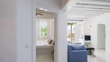 Ein modernes Interieur mit einem Bett, einem blauen Sofa, einem Fernseher und einer Steinwand.