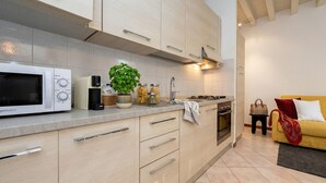 A modern kitchen with a microwave, stove, and cabinets. - DesenzanoLoft Le Petit Bijou - Restyling 2025 - Downtown (Desenzano del Garda)