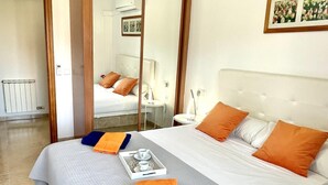 Una habitación de hotel con cama, mesita de noche, espejo y un cuadro en la pared.