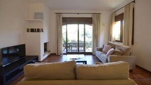 A living room with a sofa, a TV, a coffee table, and a balcony with a table and chairs. - Holiday rental semidetached with swimming pool in Begur, Centre (Begur)