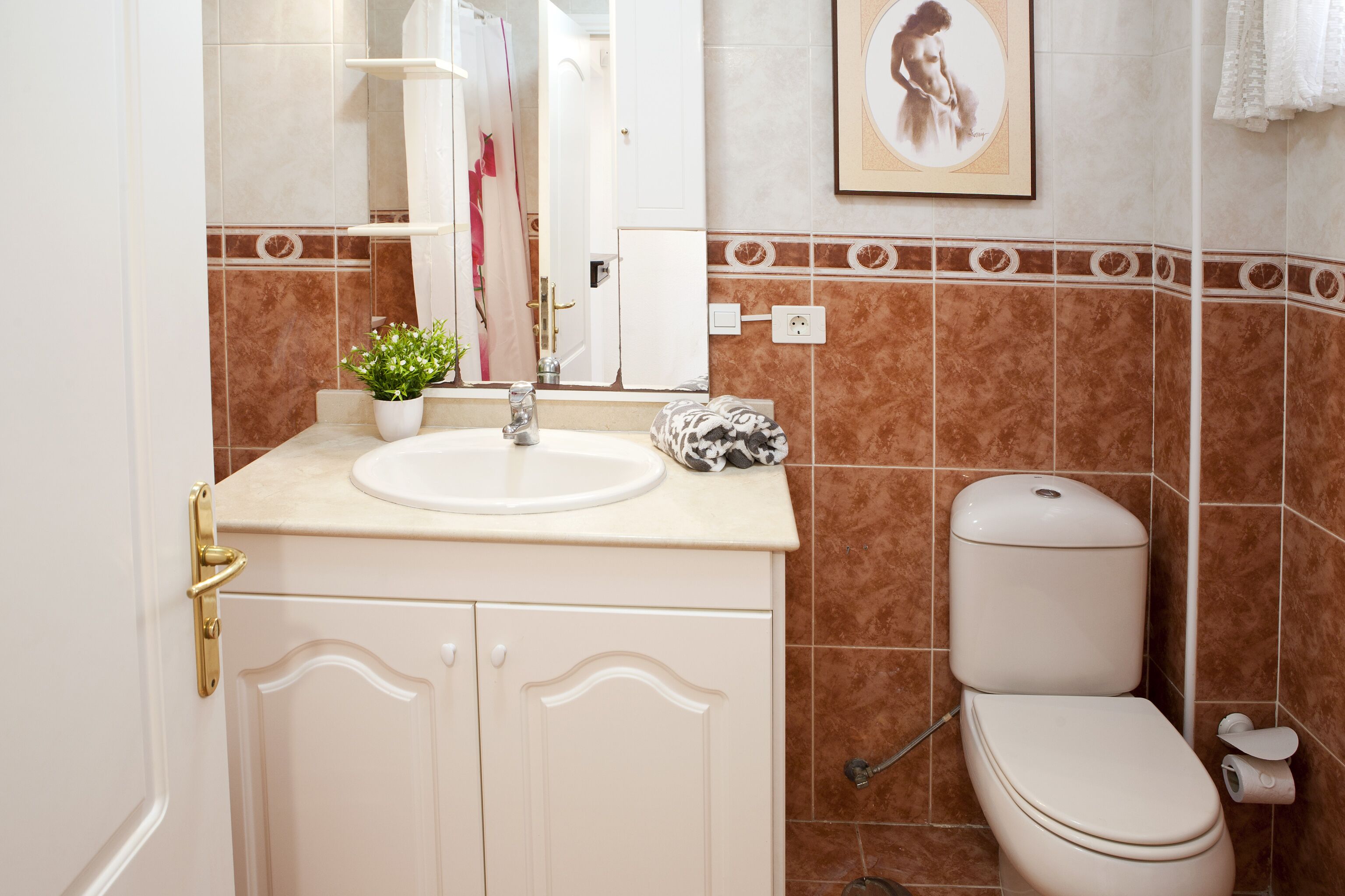 Ein Badezimmer mit Waschbecken, Toilette und Spiegel.