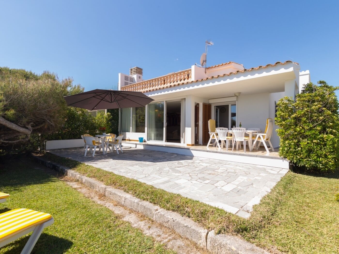 A house with a patio, outdoor furniture, and a swimming pool.