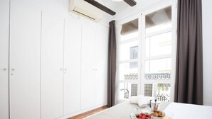 A hotel room with a bed, a breakfast tray, and a window with curtains. - Singular Stays Botanico 202 (València)