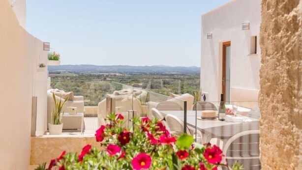 A terrace with outdoor seating, a table, and a view of the countryside. - Casa del Sol - Beautiful town house with pool and views of the countryside (Búger)