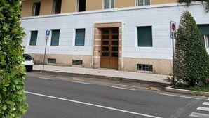 A multi-story building with balconies, a parking sign, and a gated entrance. - Da Vinci Verona, elegant apartment in Borgo Trento, 120 m², parking space (Verona)