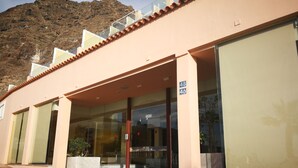 A building with a pink facade, large glass windows, and a number '48' sign.