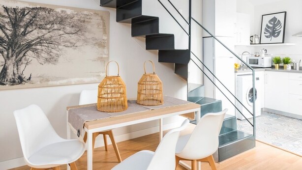 A modern kitchen with white cabinets, a wooden countertop, and a built-in oven. - Genteel Home Trinidad Grund H (Málaga)