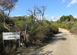 A dirt path leading to a sign that reads 'CLEARWATER HAVEN'.