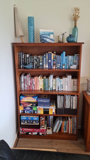 Une bibliothèque contenant divers livres et jeux de société.