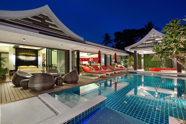 A modern hotel with a swimming pool, lounge chairs, and a well-lit interior. - Villa with Thai chef and butler by the sea in Lamai Koh Samui (Ko Samui District Province de Surat Thani)