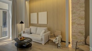 A modern living room with a sofa, armchairs, a coffee table, and a brick accent wall.