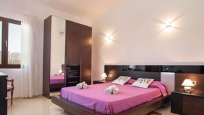 Une chambre à coucher moderne avec un grand lit, une armoire et un bureau.