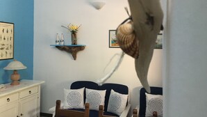Une chambre à coucher comprenant un lit, une commode, une étagère fixée au mur avec des objets décoratifs et un tableau encadré.