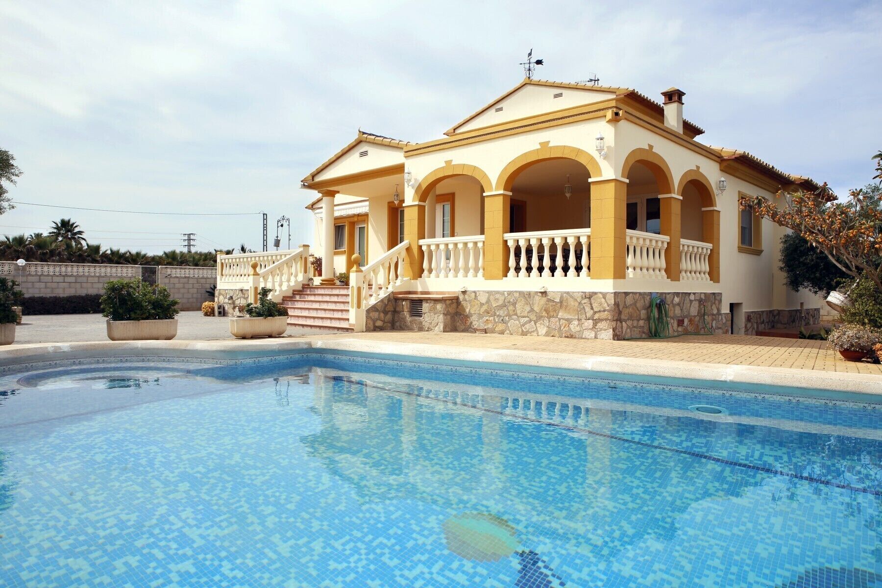A two-story house with a swimming pool in front.