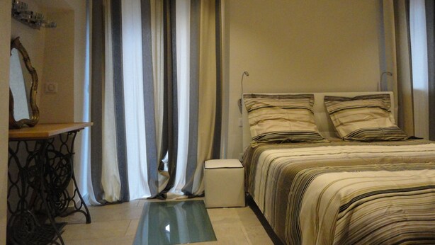 Une chambre à coucher avec un lit, des rideaux, une table de chevet et un miroir.