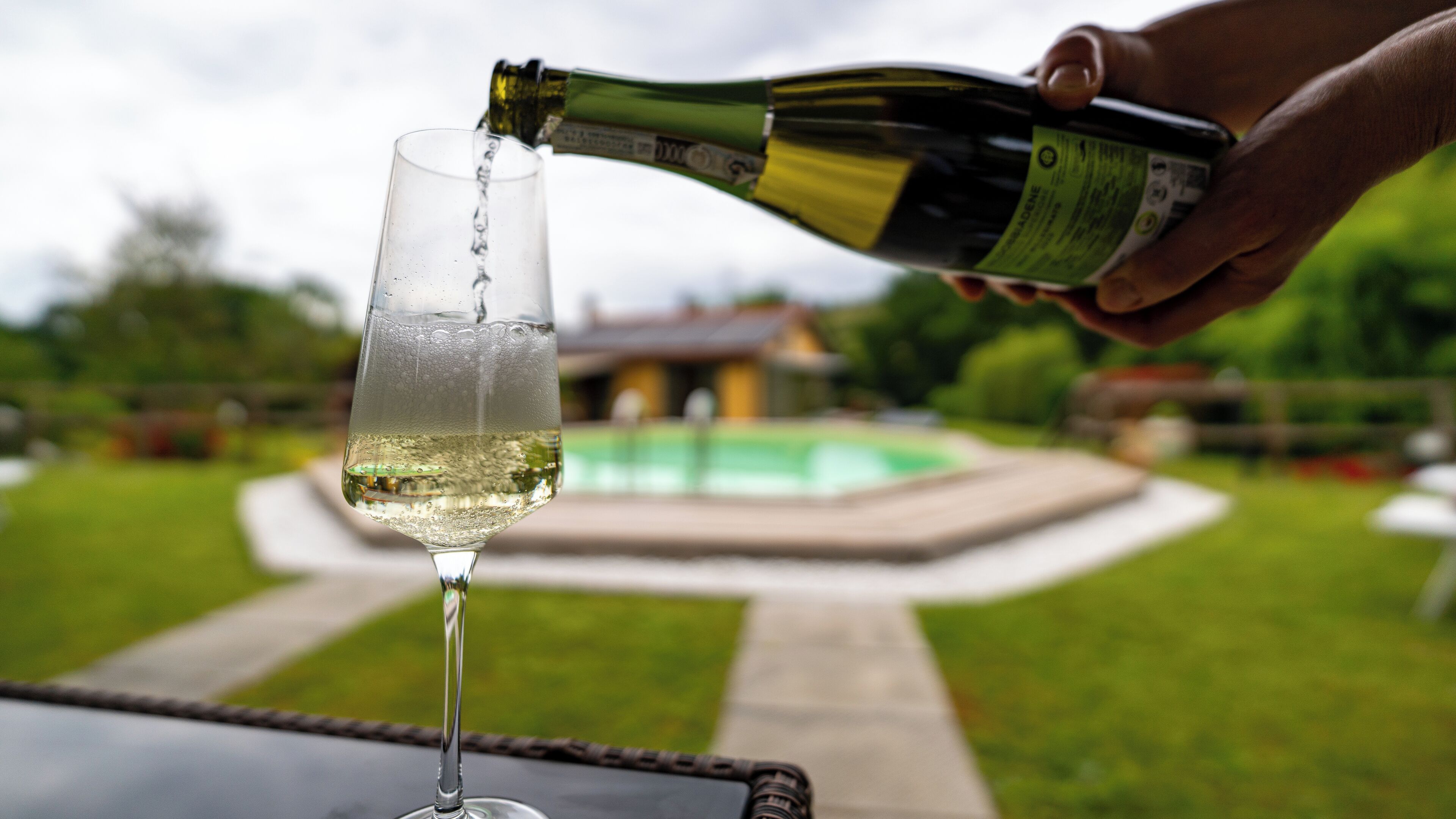 Eine Hand gießt Champagner in ein Glas.