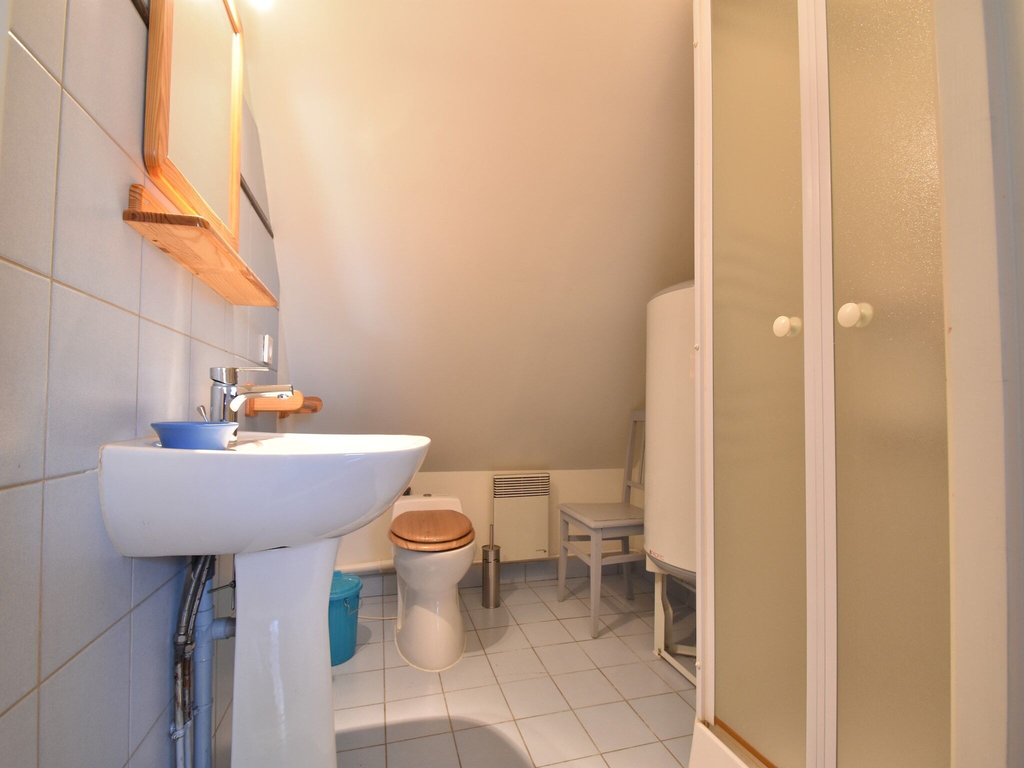 A bathroom with a white sink, a toilet, and a shower area.