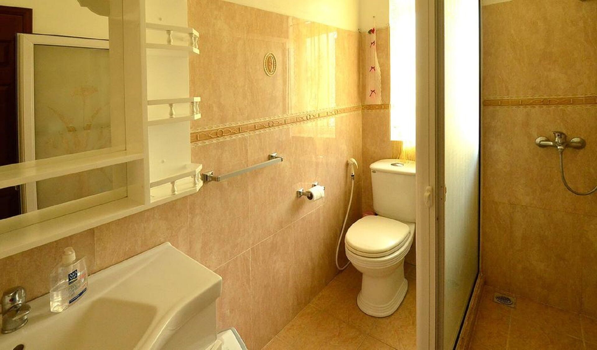 Een badkamer met toilet, wastafel en douche.