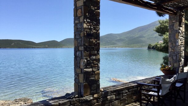 Estructura de piedra con vistas a un lago y montañas.
