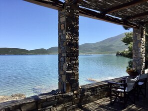 Estructura de piedra con vistas a un lago y montañas.